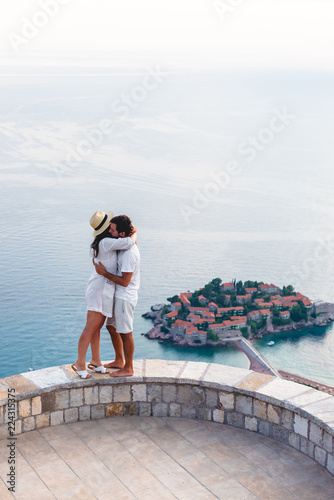 couple hugging on viewpoint near island of Sveti Stefan with hotel resort in Adriatic sea  Budva  Montenegro