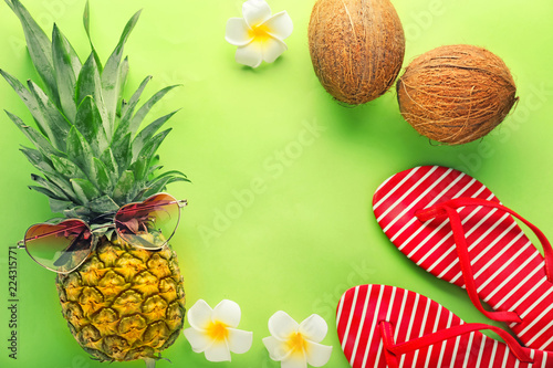 Summer composition with tropical fruits and flip-flops on color background