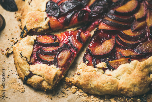 Plum galetta sweet cake on baking paper, selective focus, close-up, horizontal composition. Seasonal Fall or Autumn dessert photo