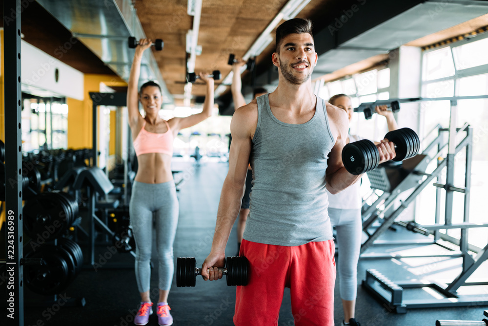 Muscular bodybuilder workout in gym doing biceps exercises Muscular bodybuilder workout in gym doing biceps exercises
