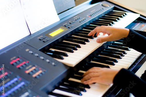 Young artist musician woman hands playing the electone in music room.