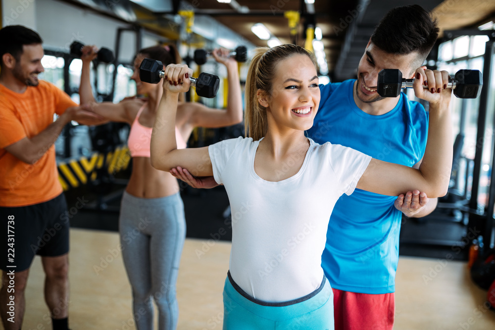Personal trainer giving instructions in gym Personal trainer giving instructions in gym