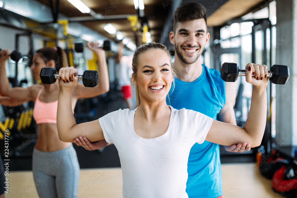 Young beautiful woman doing exercises with personal trainer Young beautiful woman doing exercises with personal trainer