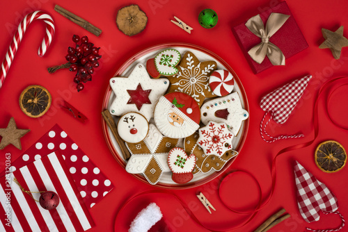 Christmas gingerbread and various decoration objects isolated on red background