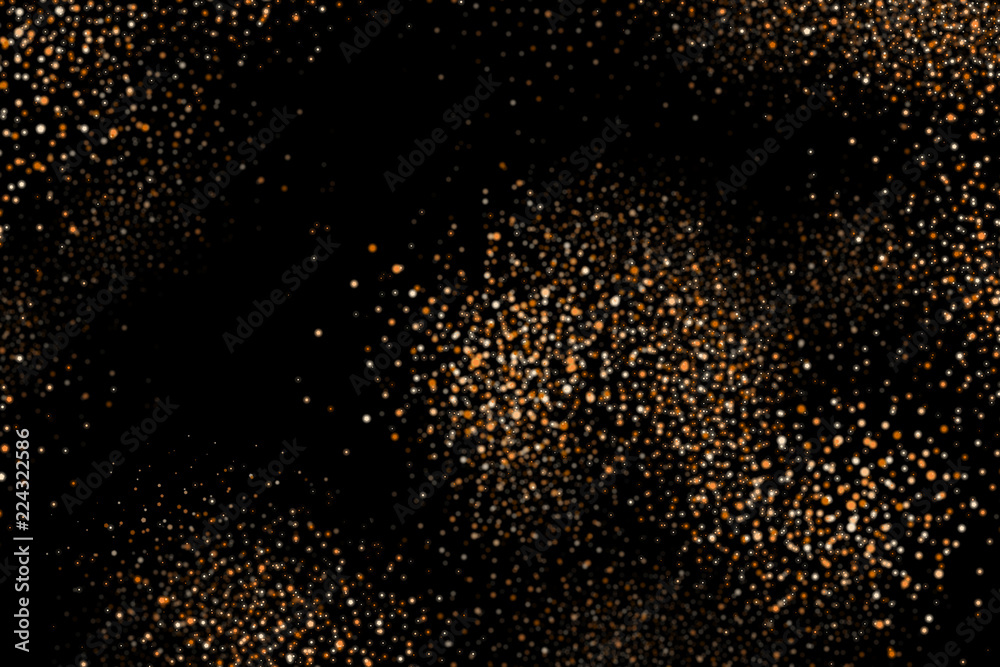 Golden explosion of confetti. Shiny dust, amber particles, lots of bright stars. Gold glitter texture isolated on black, celebration background