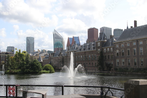 The hofvijver pool with fountain along the parliament building and the skyline of the hague.