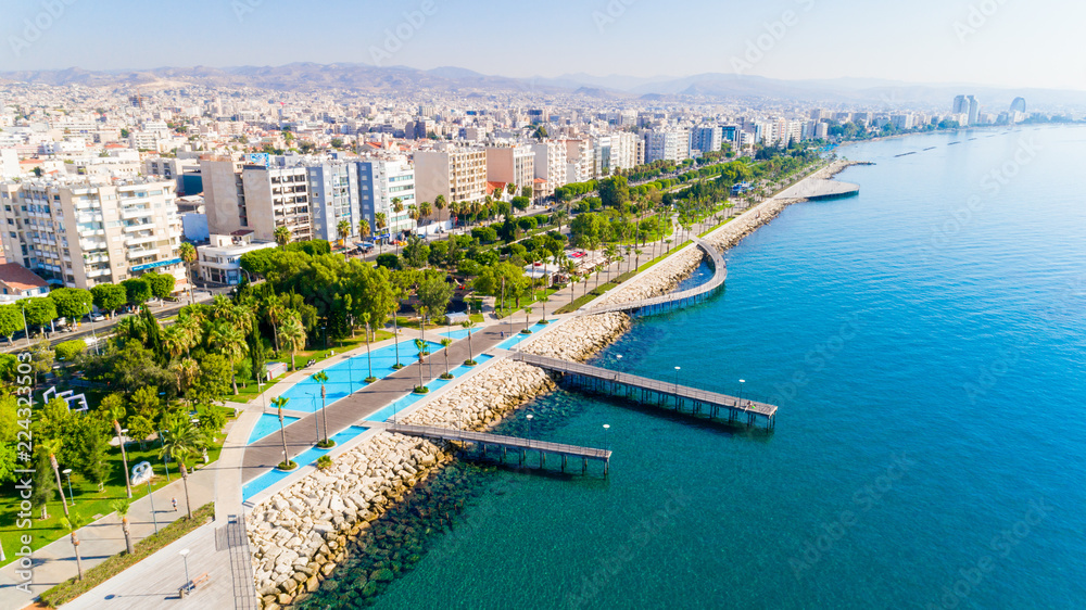 Aerial view of Molos Promenade park on coast of Limassol city centre,Cyprus. Bird's eye view of the jetty, beachfront walk path, palm trees, Mediterranean sea, piers, urban skyline and port from above - obrazy, fototapety, plakaty 