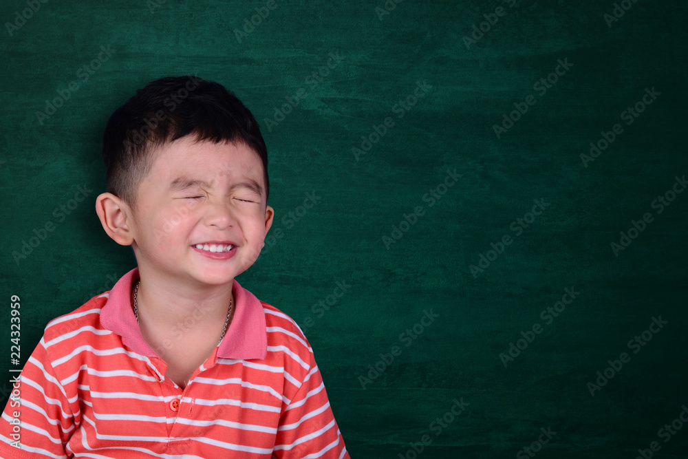 Happy Asian kid smiling on empty green chalkboard with copy space for add text or word, education and back to school concept. Happy Asian kid smiling on empty green chalkboard with copy space for add text or word, education and back to school concept.
