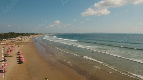 Aerial view of beautiful beach with surfers and tourists. Surfers enjoy the activity in Kuta beach in Bali, Indonesia. Beautiful view nice tropical beach from the air. 4K video, Travel concept, Aerial