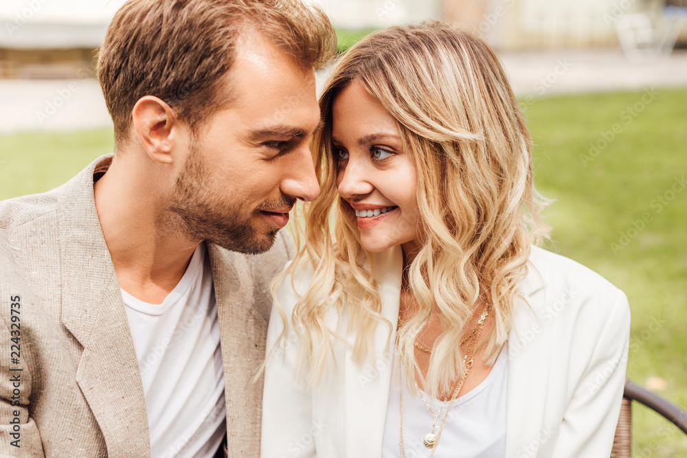 affectionate couple in autumn outfit sitting in cafe and looking at each other affectionate couple in autumn outfit sitting in cafe and looking at each other