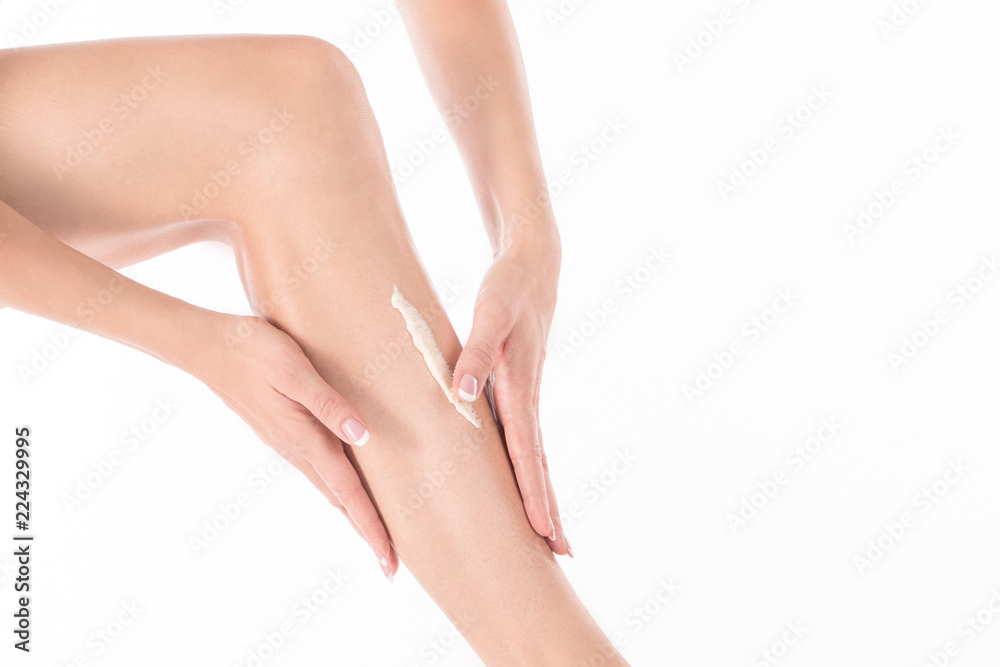 Female hands massage leg of woman with body lotion, close up Female hands massage leg of woman with body lotion, close up