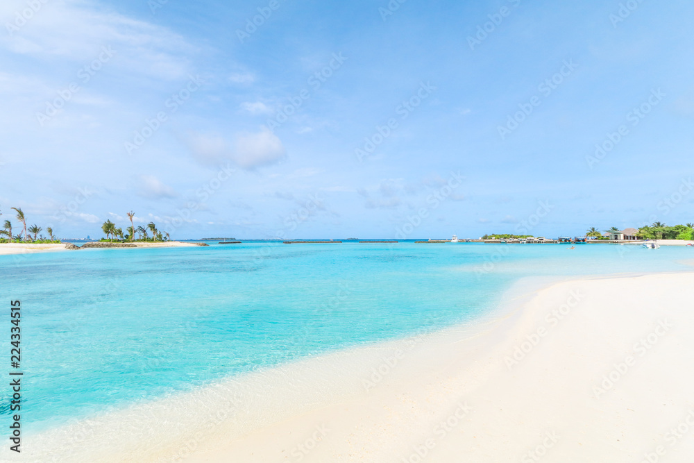 Amazing island in the Maldives ,Beautiful turquoise waters and white sandy beach with  blue sky  background for holiday vacation .