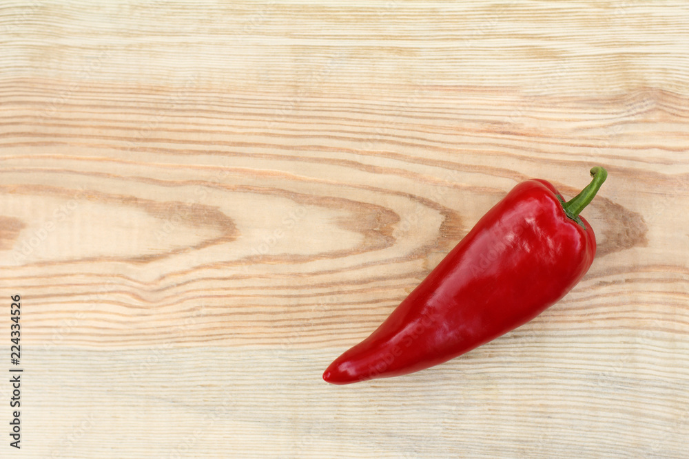  fresh red pepper/ one fresh vegetable on a wooden table top view
