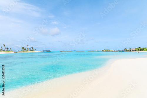 Amazing island in the Maldives ,Beautiful turquoise waters and white sandy beach with blue sky background for holiday vacation .