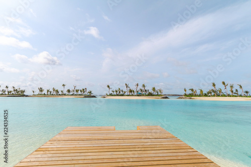 Amazing island in the Maldives ,wooden bridge and beautiful turquoise waters with blue sky background for holiday vacation .