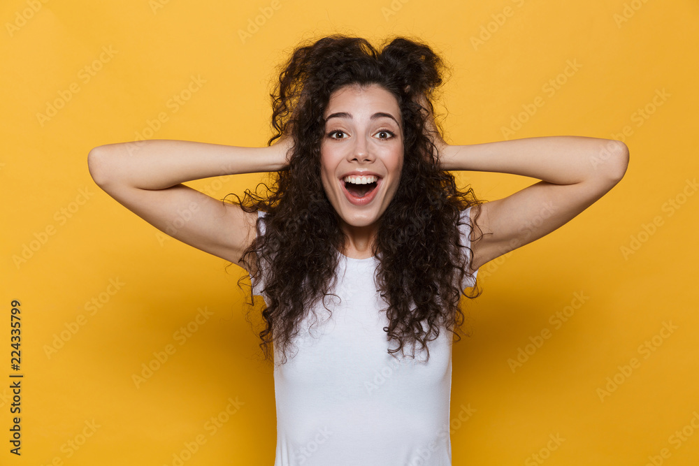 Shocked excited young cute woman posing isolated over yellow background. - obrazy, fototapety, plakaty 