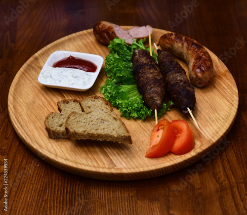 Kebab cooked meat dishes on wooden board. Serving kebab of Middle Eastern cuisine in restaurant. The hot food