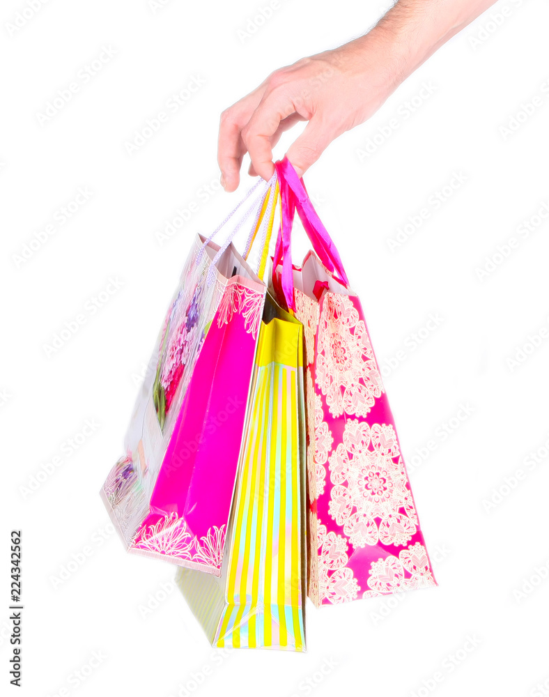 Men's hand holding pink shopping bags on white isolated background. The concept of gift for the holiday. Copy space. Vertical Studio image.