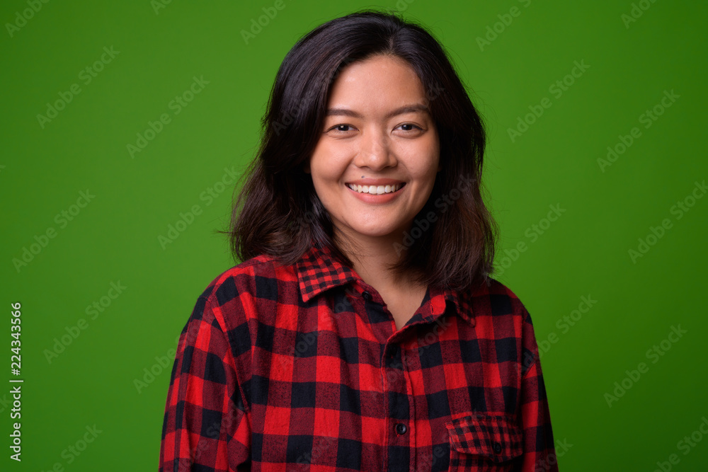 Young beautiful Asian hipster woman wearing red checkered shirt Young beautiful Asian hipster woman wearing red checkered shirt