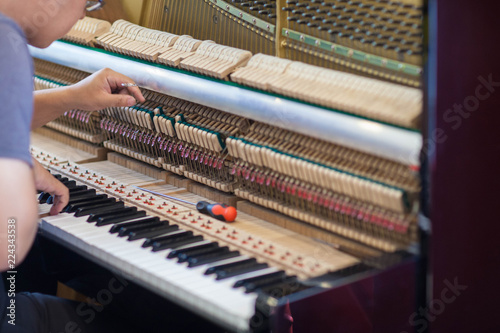 Piano repairers or musicians are repairing and customizing the piano.