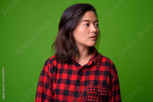 Young beautiful Asian hipster woman wearing red checkered shirt © Ranta Images