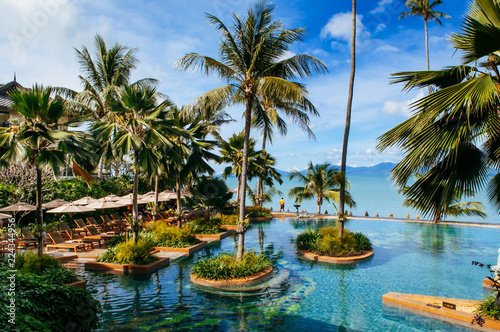 Tropical Resort pool with pool bed under umbrellas Samui island sea view