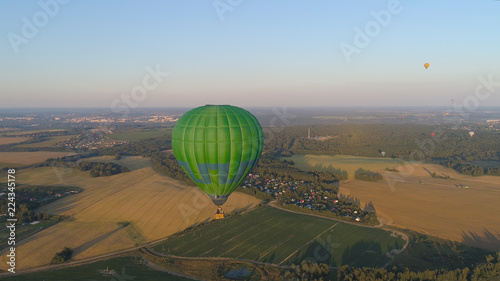 Aerial view Hot air balloon in sky over fields in countryside, beautiful sky and sunset. Aerostat fly over countryside.