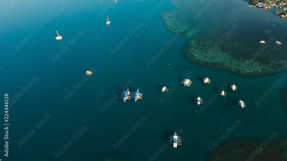 Fototapeta premium Aerial view of sailing boats and yachts in the bay. Boat and yacht in the tropical lagoon. Aerial view: tropical landscape. Tropical island. Philippines, El Nido. Travel concept