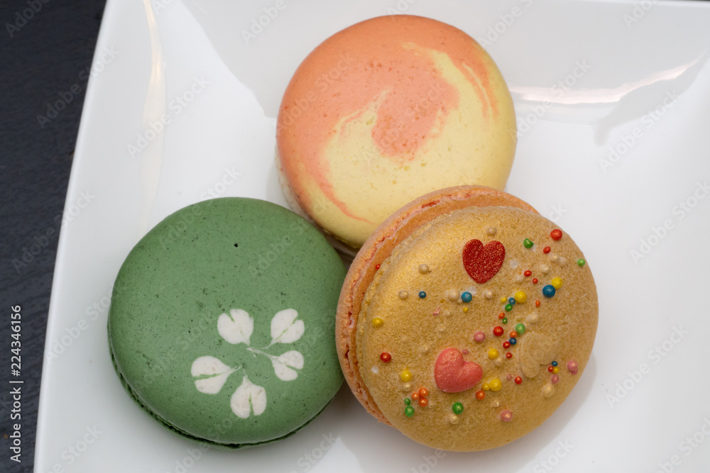 Homemade assorted macarons beautifully decorated with colorful hearts, green tea and yellow and gold color