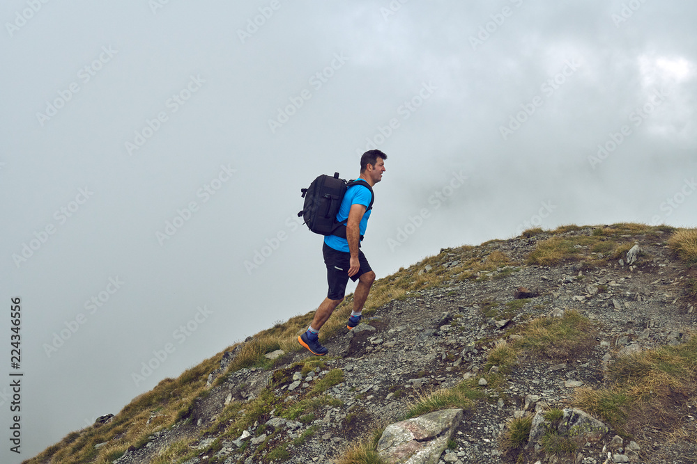 Hiker with backpack in the mountains - obrazy, fototapety, plakaty 
