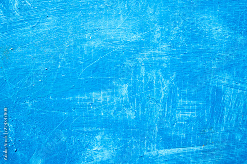 Abstract background with textured strokes of blue paint on the wooden surface.