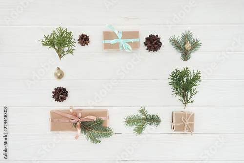 Photography top view of christmas presents, shiny golden balls, pine cones and coniferous tw