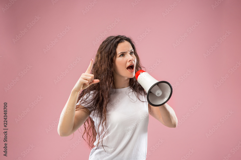 Woman making announcement with megaphone at pink studio. Human facial emotions concept. Trendy colors Woman making announcement with megaphone at pink studio. Human facial emotions concept. Trendy colors