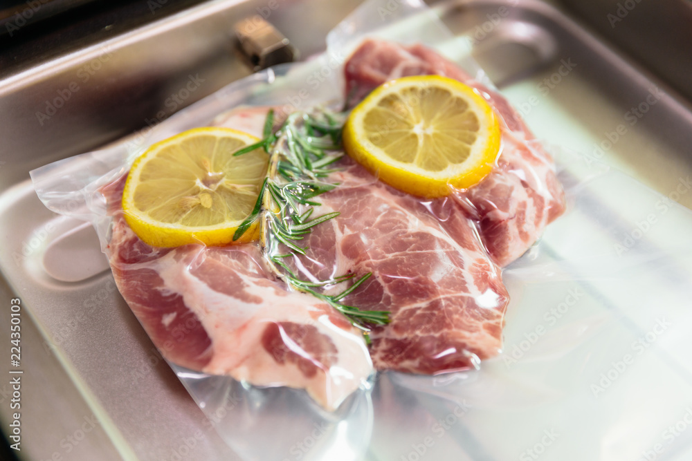 Sous vide steak with rosemary and lemons in vacuumed package. Sous vide steak with rosemary and lemons in vacuumed package.