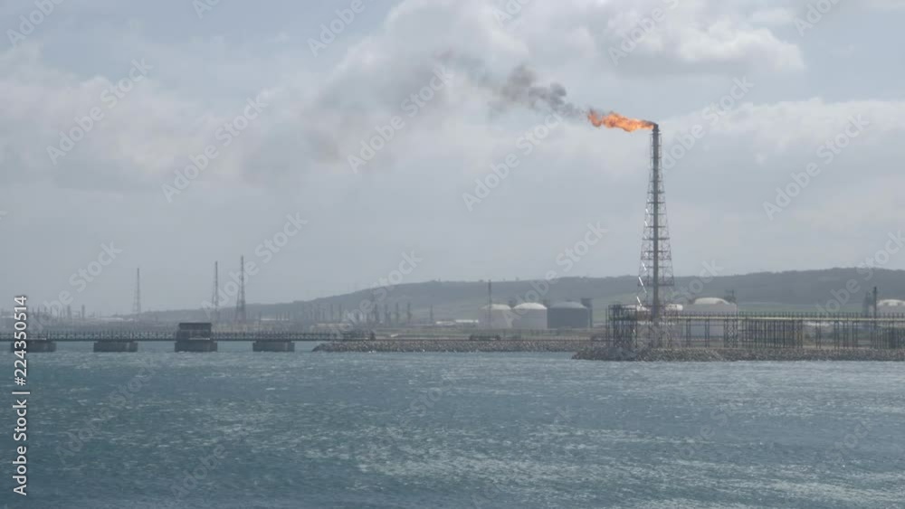 Flare stack of petrochemical refinery on strong wind Flare stack of petrochemical refinery on strong wind