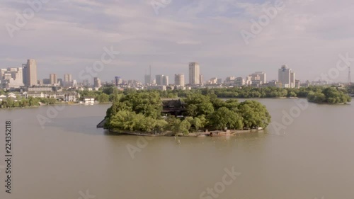 Circular aerial footage of Jiaxing City and a temple within a small island in Zhejian, China photo