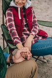 partial view of man and woman holding hands while enjoying camping together