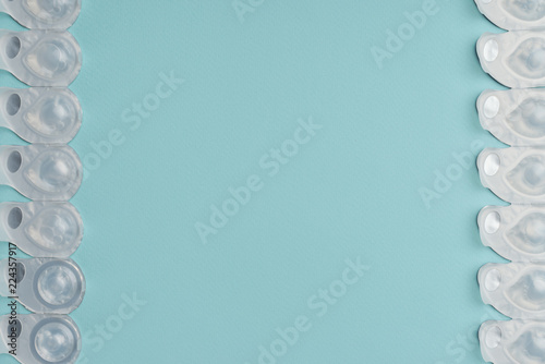 flat lay with contact lenses in containers arranged on blue background