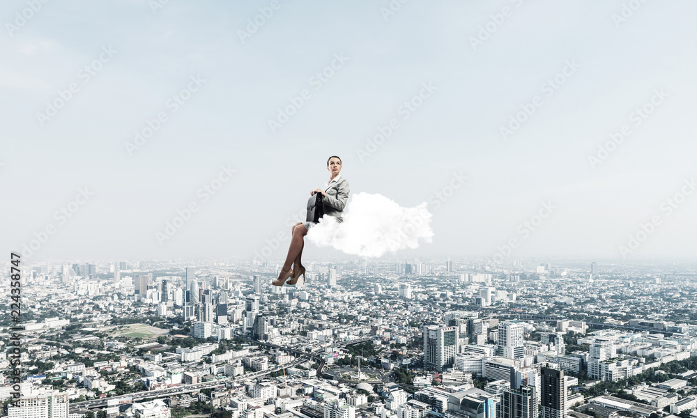 Businesswoman or accountant on cloud floating high above modern Businesswoman or accountant on cloud floating high above modern