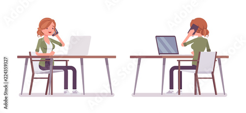 Young red-haired woman sitting and working at the desk