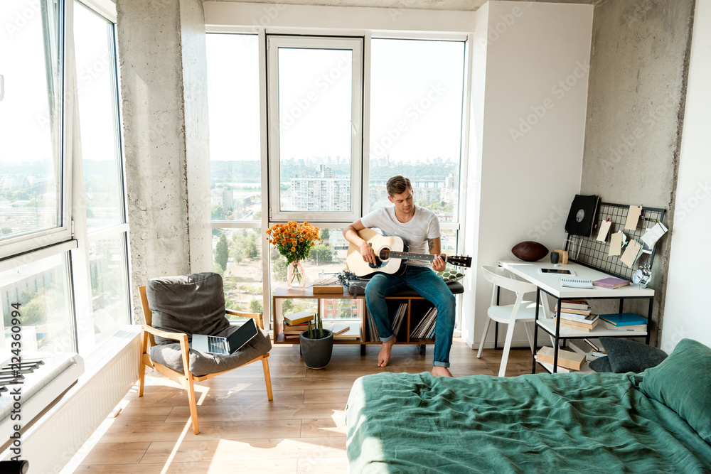 young man playing acoustic guitar at home young man playing acoustic guitar at home