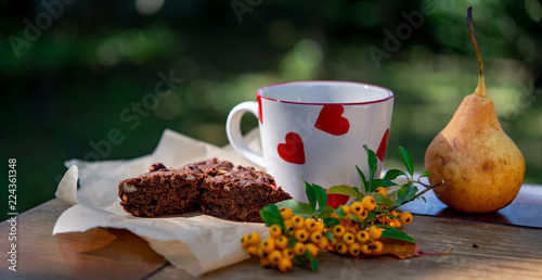 A cup of coffee and brownie cake with fall decoration
