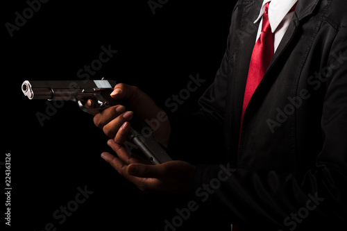 Close up Man changing gun magazines on black background.