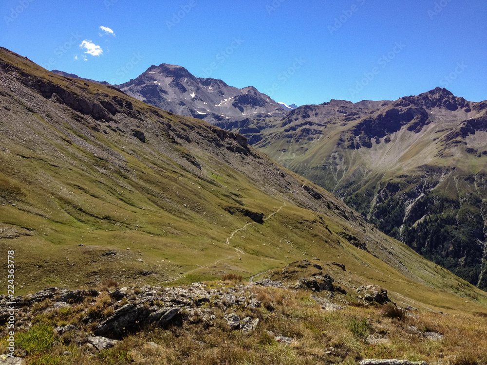 Panoramic view of a path that crosses the high pastures at the Sempione pass in Switzerland.