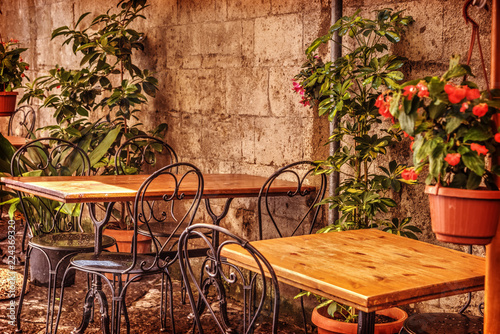 Fototapeta Naklejka Na Ścianę i Meble -  Picturesque tables and chairs in a narrow street in old town Sorrento