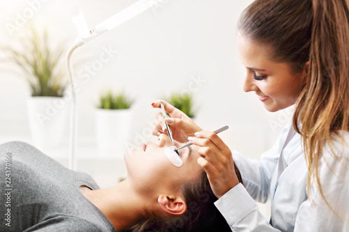 Bild auf Leinwand Adult woman having eyelash extension in professional beauty salon