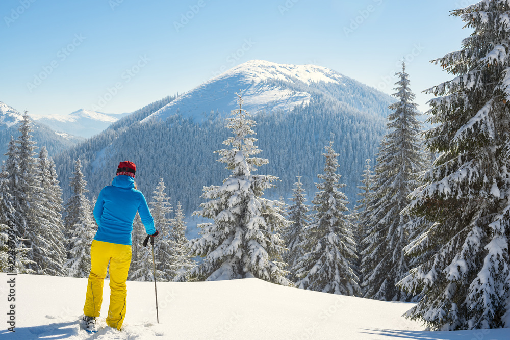 Adventurer, woman  is standing in the winter mountains