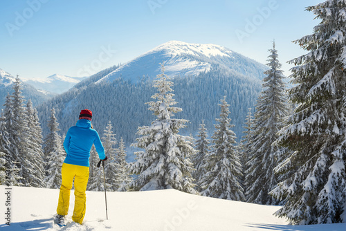 Adventurer, woman is standing in the winter mountains