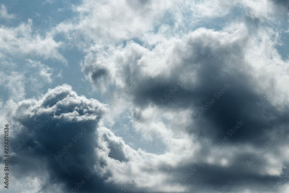 Fantastic, fluffy, white clouds against a blue sky. Rain clouds. The situation in the sky before the storm. copy space Fantastic, fluffy, white clouds against a blue sky. Rain clouds. The situation in the sky before the storm. copy space