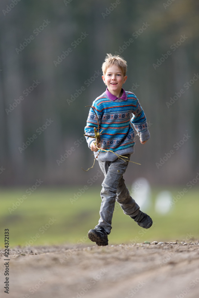 Fototapeta premium Boy running with branch